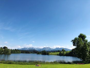 Scenic view of lake against clear blue sky