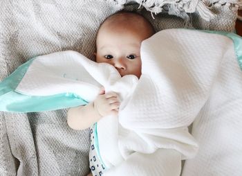 High angle view of baby girl lying on bed at home