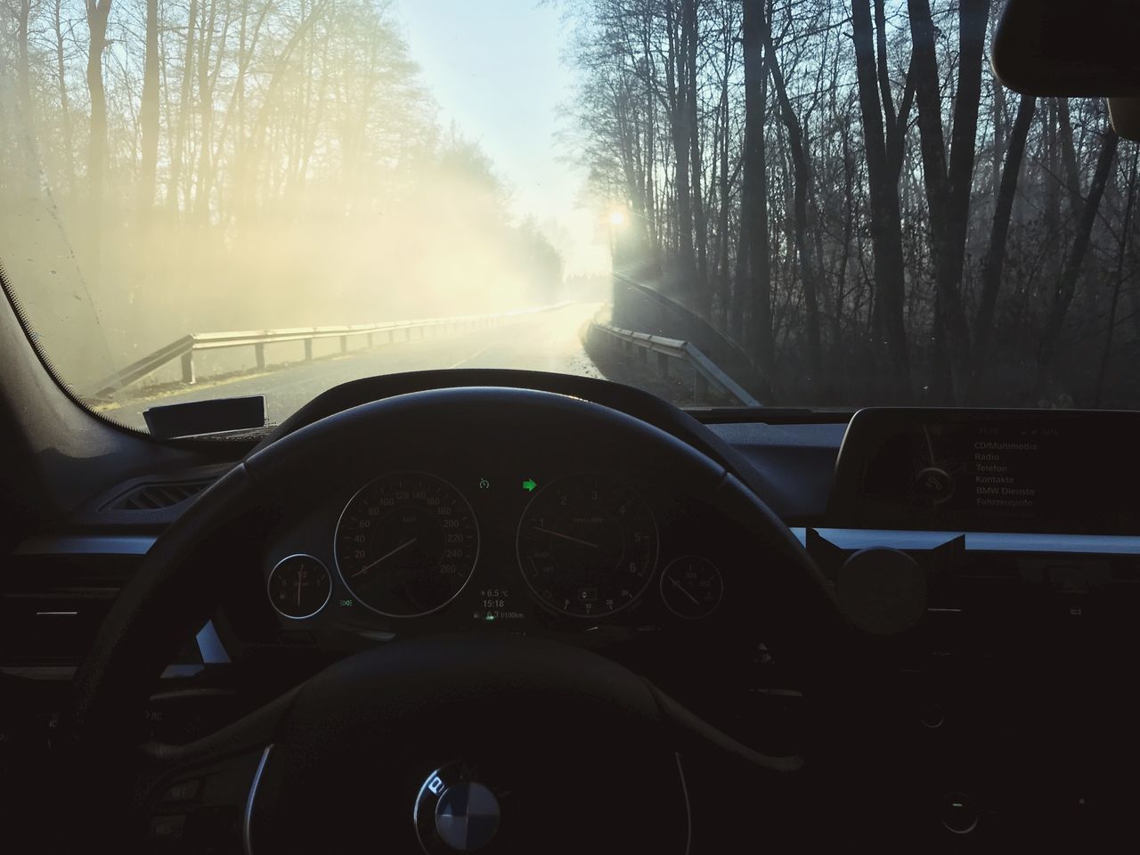 CAR MOVING ON ROAD SEEN THROUGH WINDSHIELD OF BUS