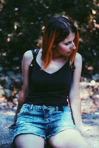 Thoughtful woman sitting on wall 