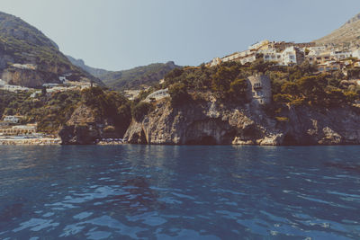 Scenic view of sea and mountains against clear sky