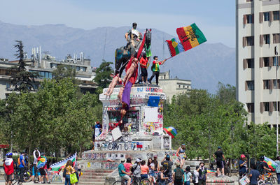 People at town square against sky in city