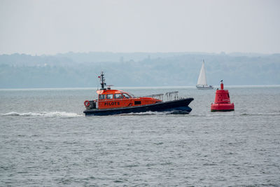 05-07-2023 portsmouth, hampshire, uk a pilot boat at see guiding a ship into port