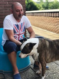 Man with dog sitting outdoors