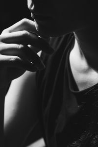 Close-up of man smoking cigarette against black background