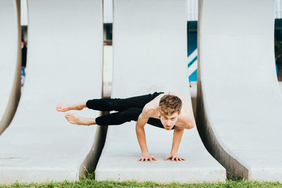 Full length of shirtless man exercising outdoors