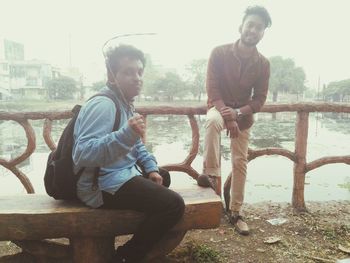 Young couple sitting on sidewalk in city