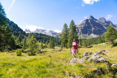 Woman standing on countryside landscape against mountain range