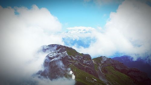 Scenic view of mountains against cloudy sky