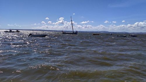 Sailboats in sea against sky