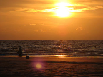 Scenic view of sea against sky during sunset while casting net