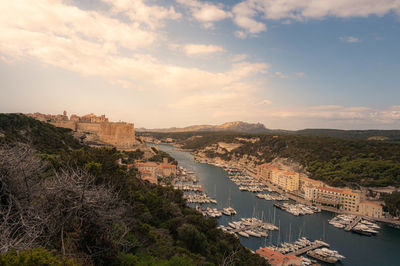 High angle view of townscape by sea against sky during sunset