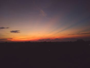 Scenic view of silhouette landscape against dramatic sky during sunset