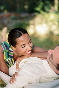 Portrait of young woman lying on bed at park