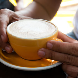 Midsection of man holding coffee cup