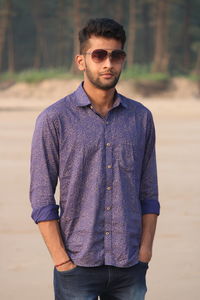 Portrait of young man wearing sunglasses standing outdoors