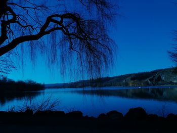 Scenic view of lake against blue sky at dusk