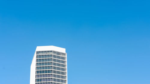 Low angle view of modern building against clear blue sky