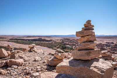 Stack of stones or rocks on mountain landscape against sky