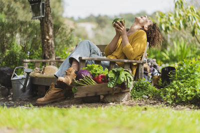 Young woman sitting on grass at field