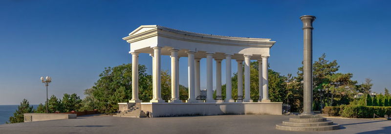 Colonnade and obelisk of glory in chernomorsk city on a sunny summer morning