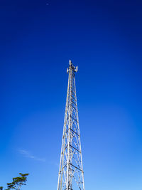 Low angle view of communications tower against clear blue sky