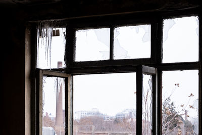 Buildings seen through window of abandoned house