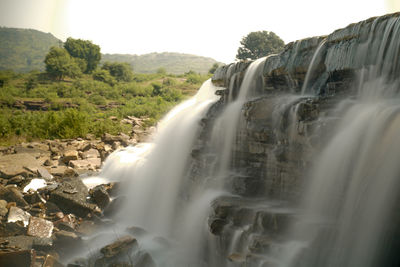 Scenic view of waterfall against sky