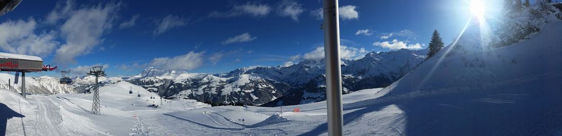 Scenic view of snow covered mountains against cloudy sky