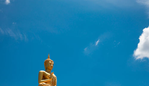 Statue of buddha against blue sky