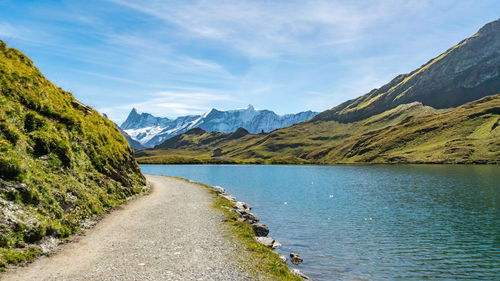 Scenic view of lake by mountains against sky