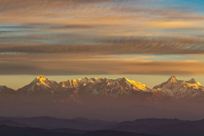 Scenic view of snowcapped mountains against sky during sunset