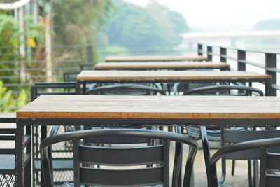 Empty chairs and tables at sidewalk cafe