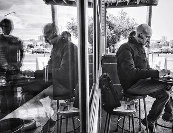 Rear view of man sitting by window