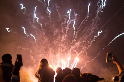 People watching firework display at night