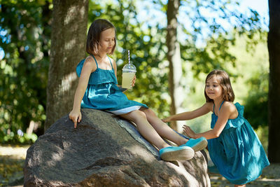 Two little girls drinking lemonade in park