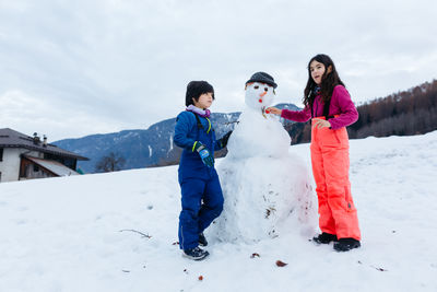 Portrait of smiling couple standing on snow covered landscape