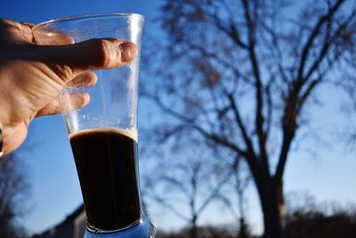 Close-up of hand holding beer glass