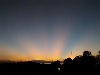 Silhouette trees against sky at sunset
