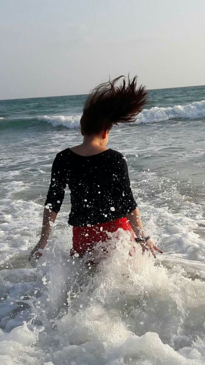 water, sea, beach, horizon over water, lifestyles, leisure activity, wave, shore, vacations, young adult, standing, full length, person, surf, sand, nature, beauty in nature, sky