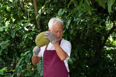 Man holding umbrella standing by plants