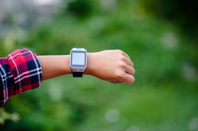 Close-up of woman hand wearing smart watch outdoors