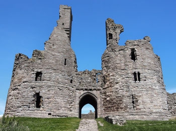 Low angle view of old ruins against clear blue sky