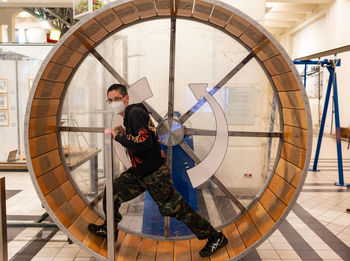 Full length of man wearing mask in wooden wheel