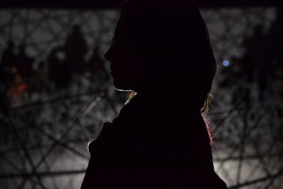 Side view of silhouette woman standing against blurred background