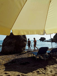 People standing on beach against sky