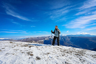 Rear view of man standing on snow covered mountain