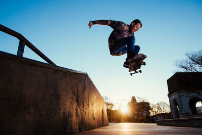 Full length of man in mid-air while performing stunt with skateboard