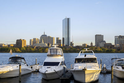 Docked sailing boats on a charles river with view of boston skyscrapers