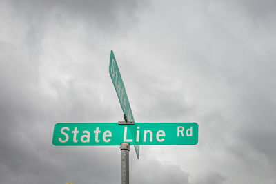 Low angle view of road sign against sky